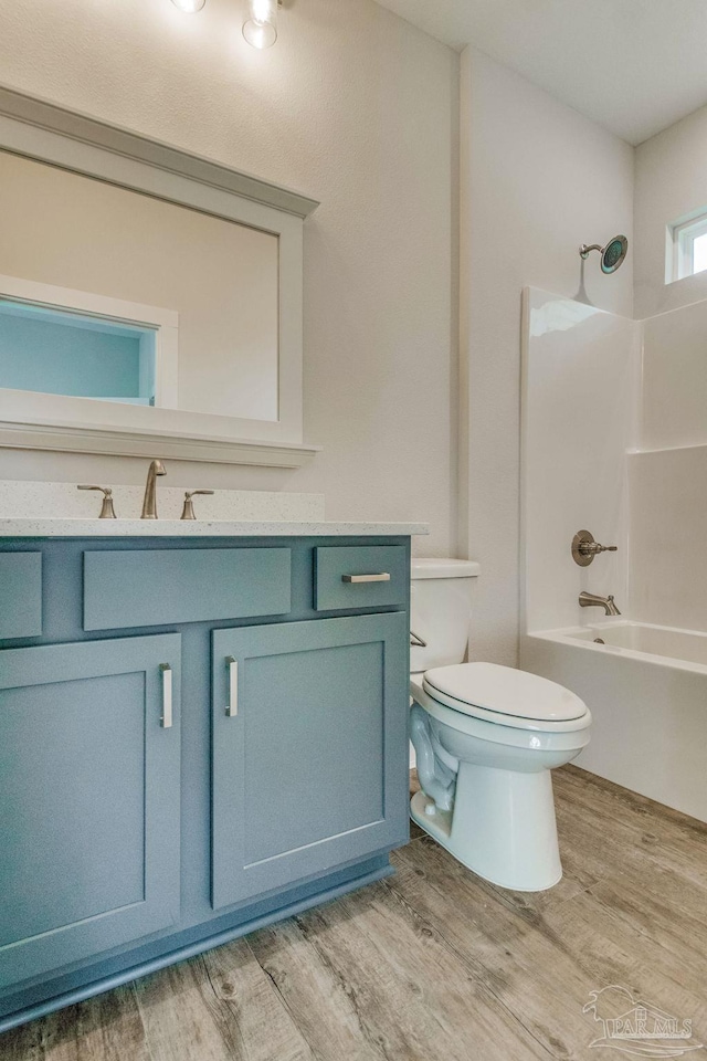 full bathroom featuring vanity, hardwood / wood-style flooring, toilet, and shower / bathtub combination