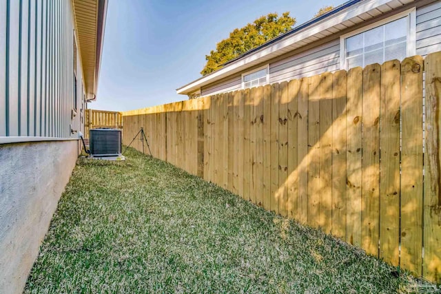 view of yard featuring central AC unit and fence