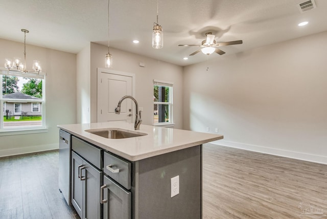 kitchen with plenty of natural light, sink, wood-type flooring, and a center island with sink