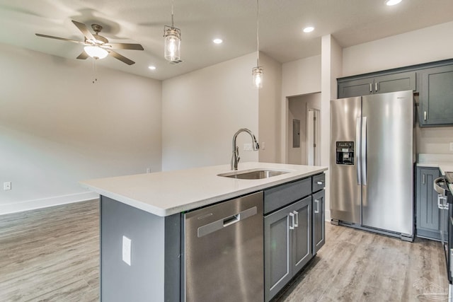 kitchen featuring sink, light hardwood / wood-style floors, pendant lighting, a center island with sink, and appliances with stainless steel finishes