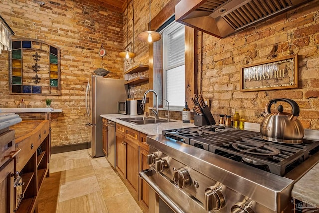 kitchen featuring sink, hanging light fixtures, stainless steel appliances, light stone counters, and custom exhaust hood