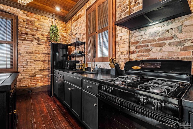 kitchen featuring gas stove, sink, a healthy amount of sunlight, brick wall, and ventilation hood