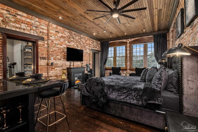 bedroom featuring ceiling fan, dark hardwood / wood-style flooring, wood ceiling, and brick wall