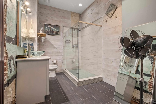 bathroom featuring vanity, toilet, and a shower with shower door