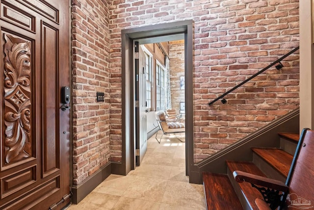 entryway featuring light tile patterned floors and brick wall