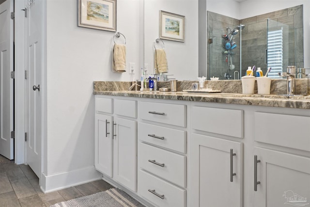 bathroom featuring vanity and a shower with door