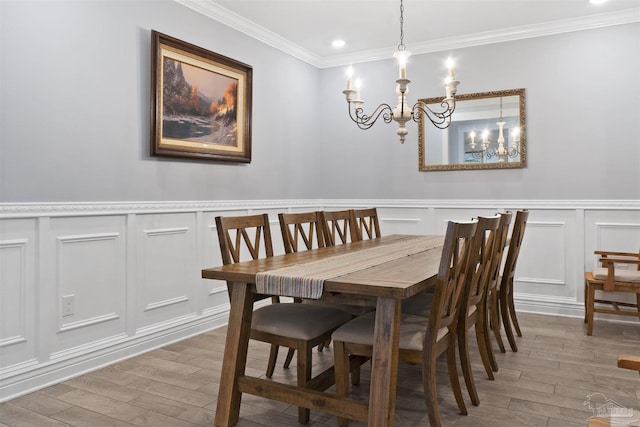 dining area featuring ornamental molding, hardwood / wood-style floors, and a notable chandelier