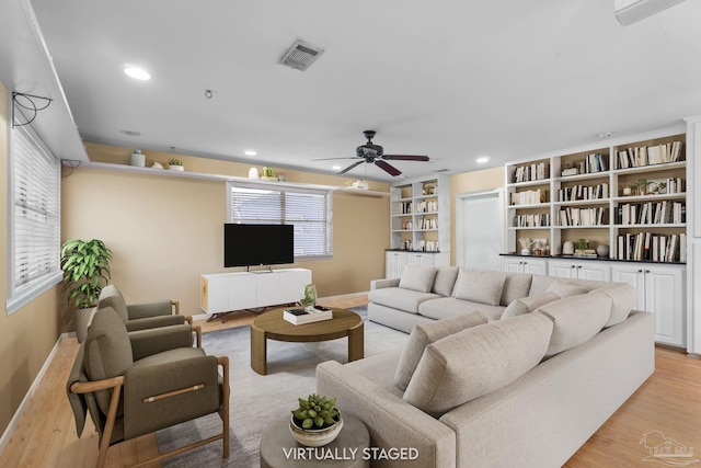 living area with recessed lighting, visible vents, and light wood finished floors