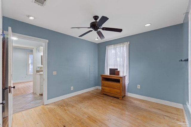 unfurnished bedroom with light wood finished floors, baseboards, multiple windows, and visible vents