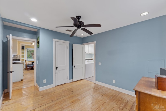 bedroom featuring washer / dryer, light wood-type flooring, visible vents, and baseboards