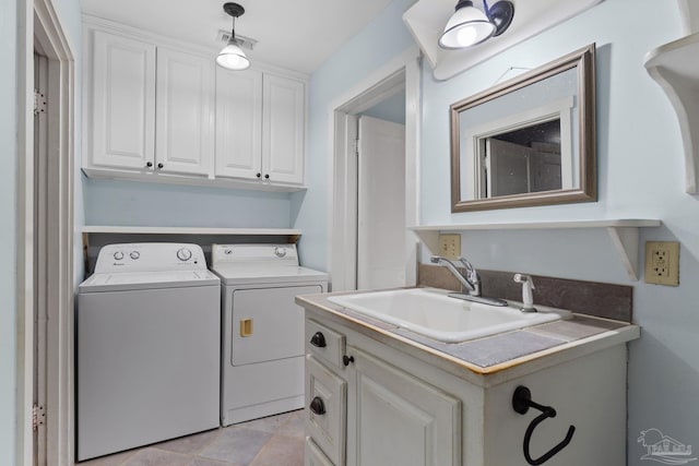 washroom featuring cabinet space, washer and clothes dryer, and a sink