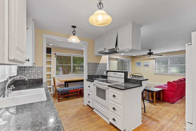 kitchen featuring a breakfast bar, a sink, light wood-style floors, white cabinets, and white electric range oven