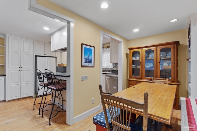 dining area with baseboards, light wood-style flooring, and recessed lighting