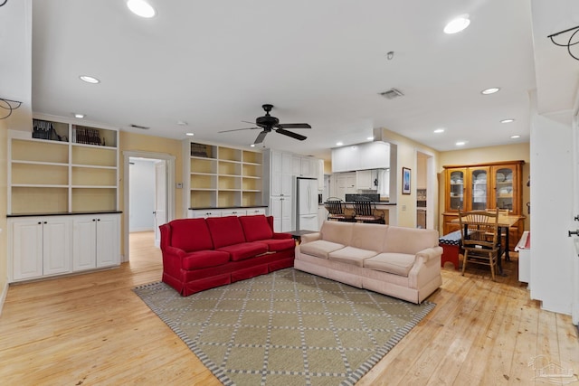 living room with light wood-type flooring, visible vents, ceiling fan, and recessed lighting