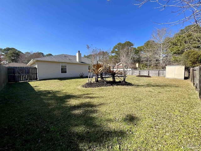 view of yard with an outbuilding, a storage unit, and a fenced backyard