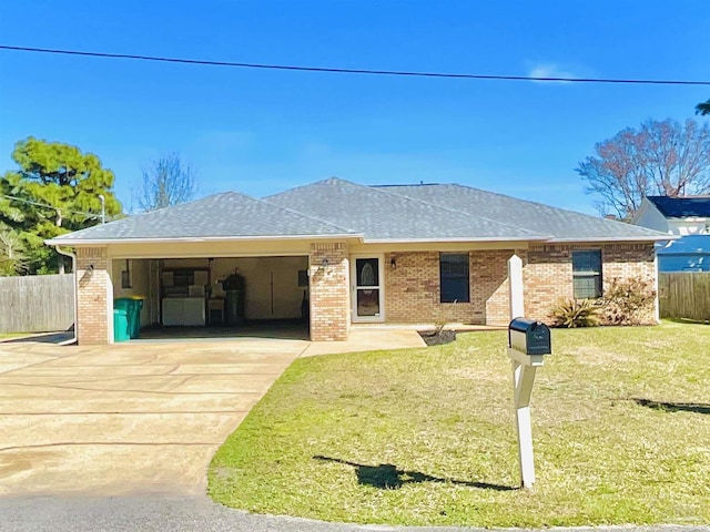 single story home with an attached garage, concrete driveway, brick siding, and a front yard