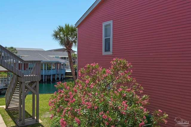 view of property exterior featuring a yard and stairway