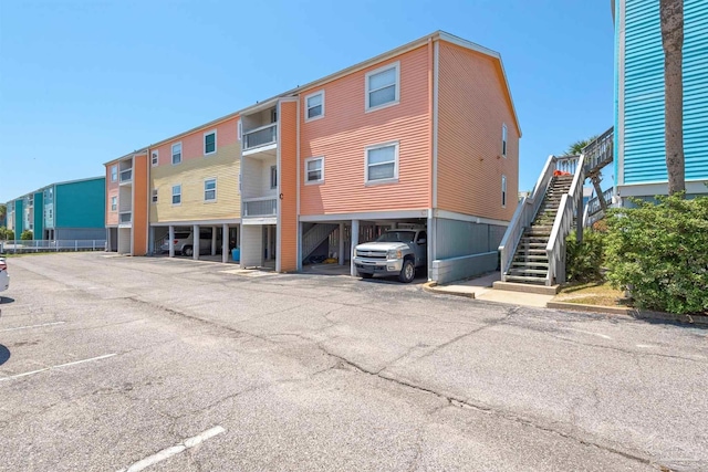 view of building exterior with covered parking and stairs