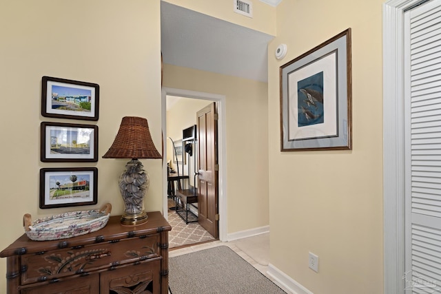 hallway with visible vents and baseboards