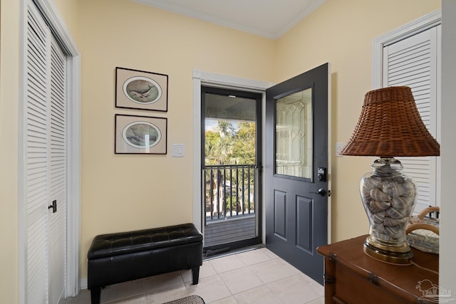 entryway featuring light tile patterned floors and crown molding