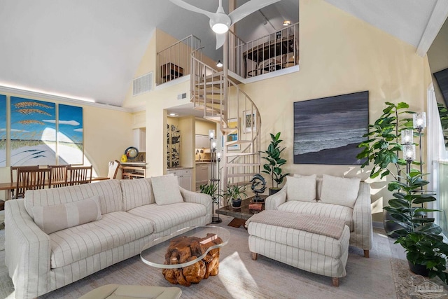 living area with stairs, a ceiling fan, visible vents, and high vaulted ceiling