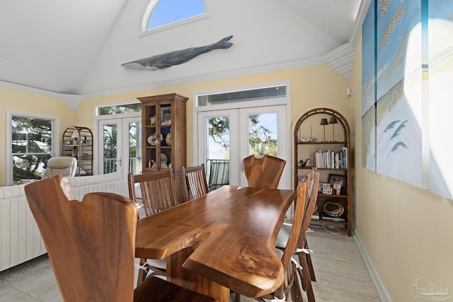 dining room with radiator, baseboards, ornamental molding, french doors, and high vaulted ceiling