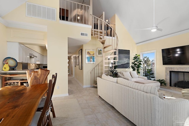 living room featuring visible vents, a multi sided fireplace, high vaulted ceiling, and stairway