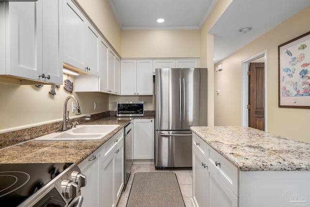 kitchen with a sink, stainless steel appliances, light stone counters, and white cabinets