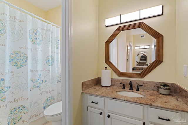 bathroom with vanity, a shower with shower curtain, and toilet