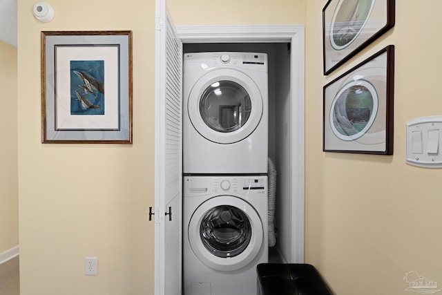 laundry area with stacked washing maching and dryer