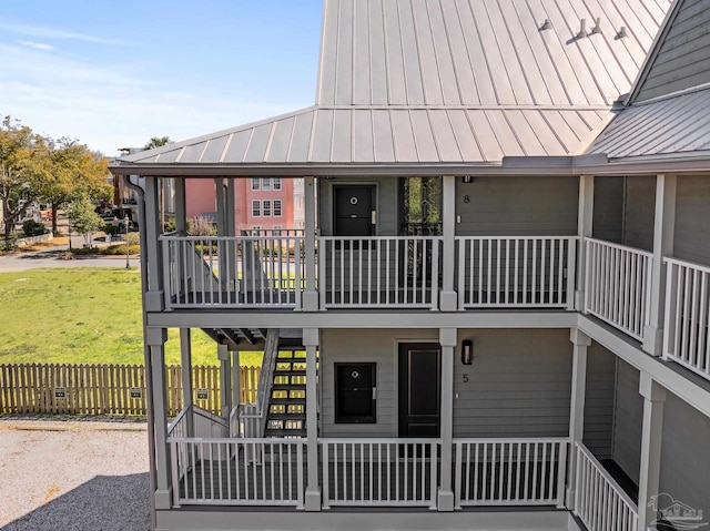 rear view of property featuring stairway, metal roof, and a standing seam roof