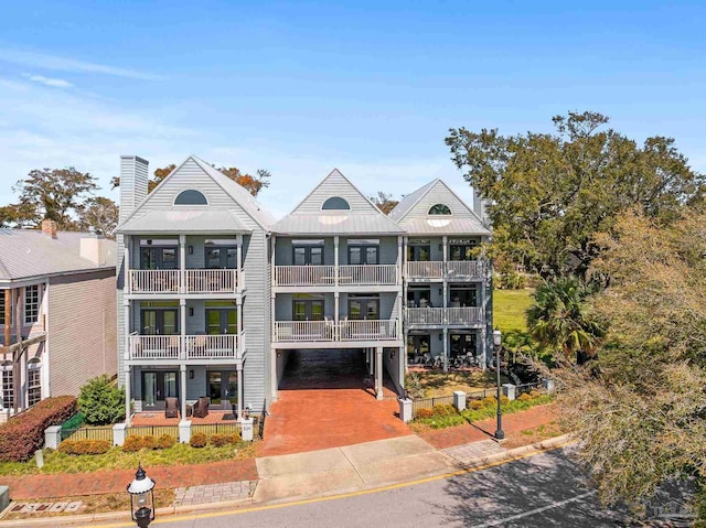 view of front of house featuring a chimney, fence, a standing seam roof, and metal roof