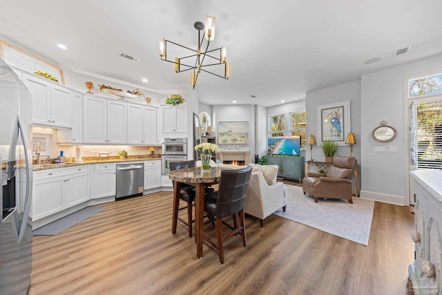 217 W Jackson St Unit 12, Pensacola, FL 32501 - dining area featuring a chandelier, recessed lighting, light wood finished floors, and visible vents