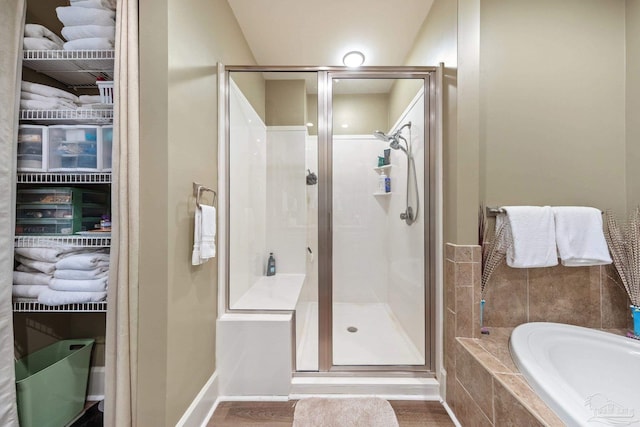 217 W Jackson St Unit 12, Pensacola, FL 32501 - bathroom with a bath, baseboards, a stall shower, and wood finished floors
