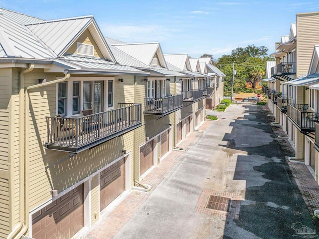 217 W Jackson St Unit 12, Pensacola, FL 32501 - view of home's exterior featuring driveway, metal roof, a garage, a residential view, and a standing seam roof