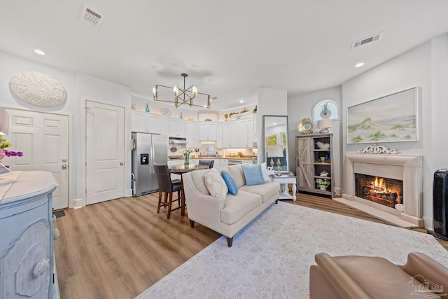 217 W Jackson St Unit 12, Pensacola, FL 32501 - living area with a notable chandelier, visible vents, and light wood-style flooring