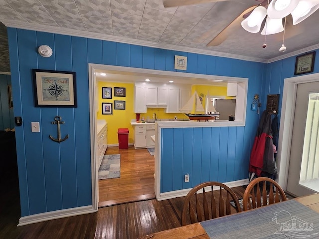 kitchen with stainless steel refrigerator with ice dispenser, white cabinetry, crown molding, hardwood / wood-style flooring, and ceiling fan