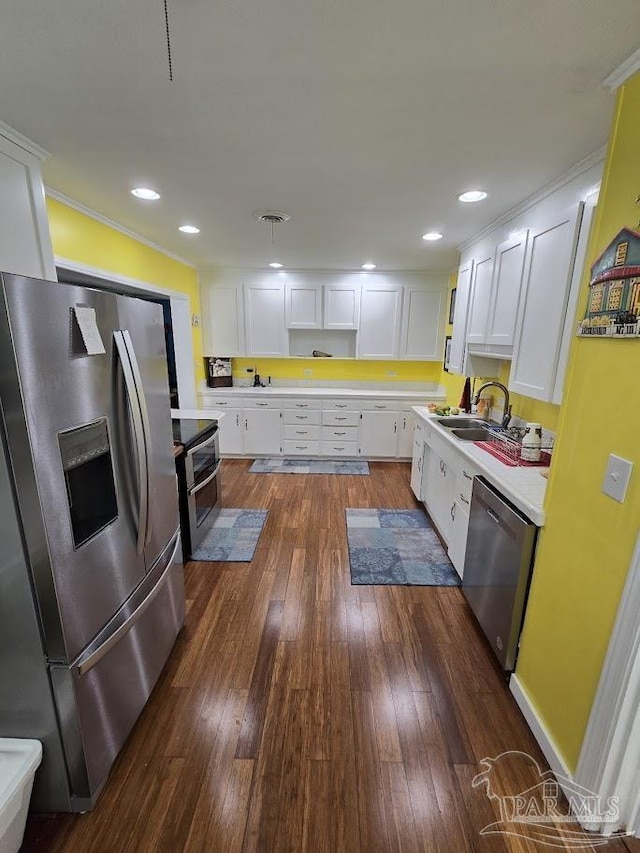 kitchen with sink, crown molding, dark wood-type flooring, stainless steel appliances, and white cabinets