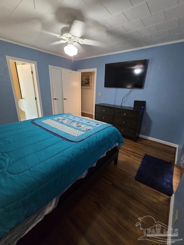 bedroom with crown molding, dark wood-type flooring, and ceiling fan