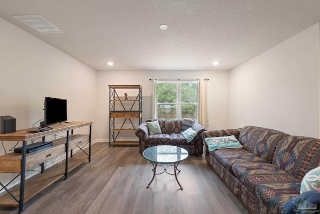 living room with wood-type flooring and a textured ceiling