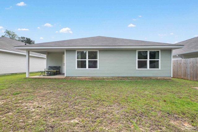 rear view of property featuring a lawn and a patio area