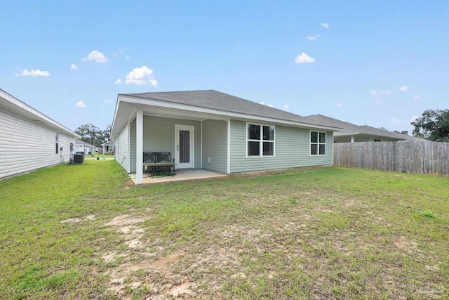 back of house featuring a lawn, cooling unit, and a patio area