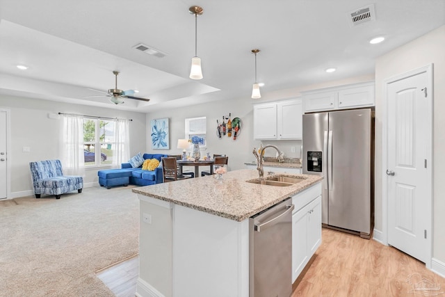 kitchen featuring a sink, appliances with stainless steel finishes, white cabinets, a ceiling fan, and decorative light fixtures