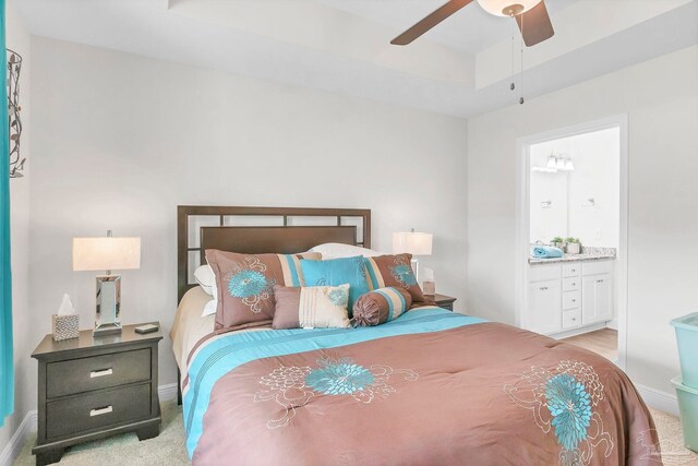 bedroom with light carpet, baseboards, connected bathroom, and ceiling fan