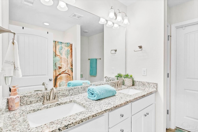 bathroom featuring double vanity and curtained shower