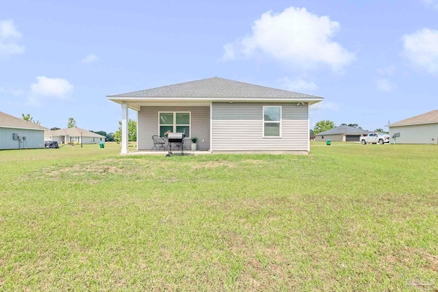 back of house featuring a patio area and a yard