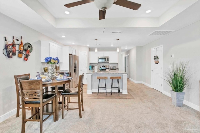dining room with light colored carpet, ceiling fan, baseboards, and recessed lighting