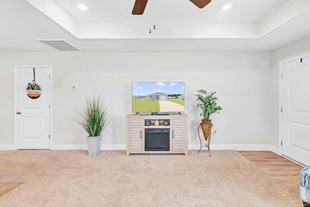 carpeted living room featuring ceiling fan, a raised ceiling, baseboards, and recessed lighting