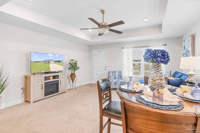 dining space featuring a tray ceiling, light carpet, baseboards, ceiling fan, and recessed lighting