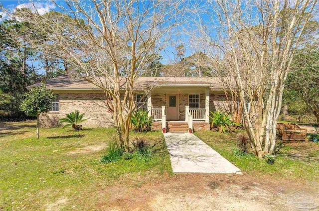 3036 Laurel Dr, Gulf Breeze, FL 32563 - view of front facade with a porch, a front lawn, and brick siding